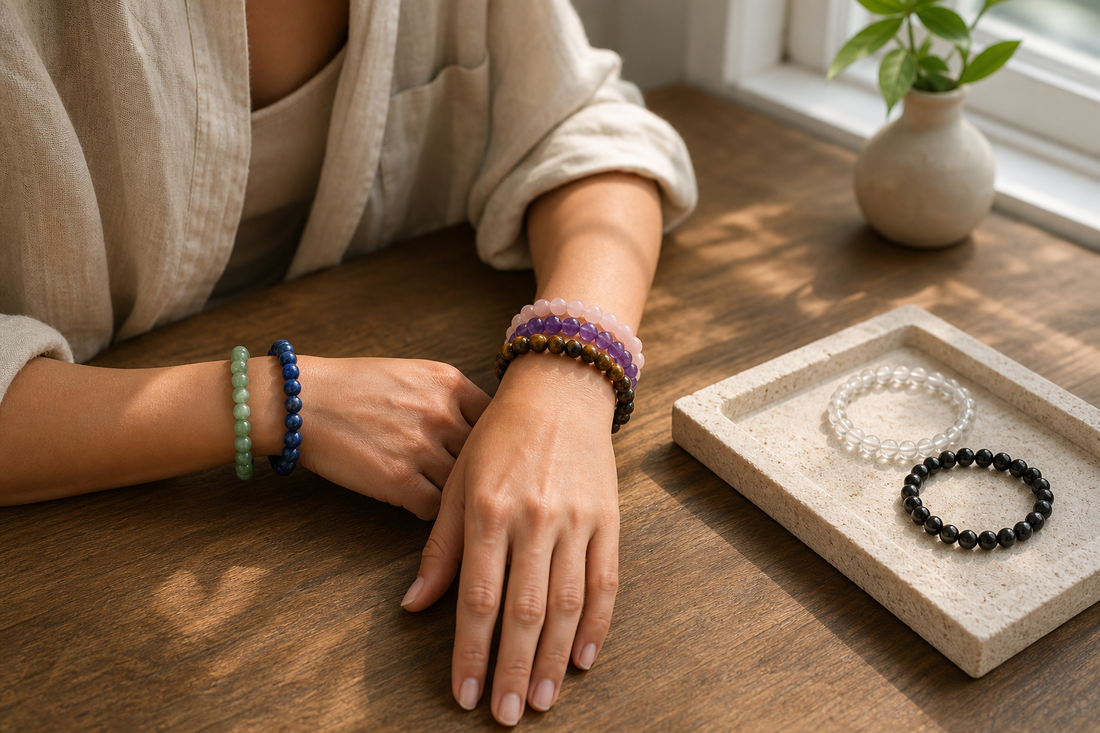 A woman styling several natural crystal bracelets in warm window light
