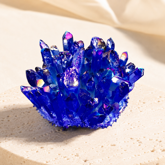 Blue aura crystal geode point on warm ivory stone