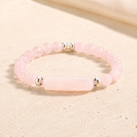 Rose quartz bridge bracelet on warm ivory stone