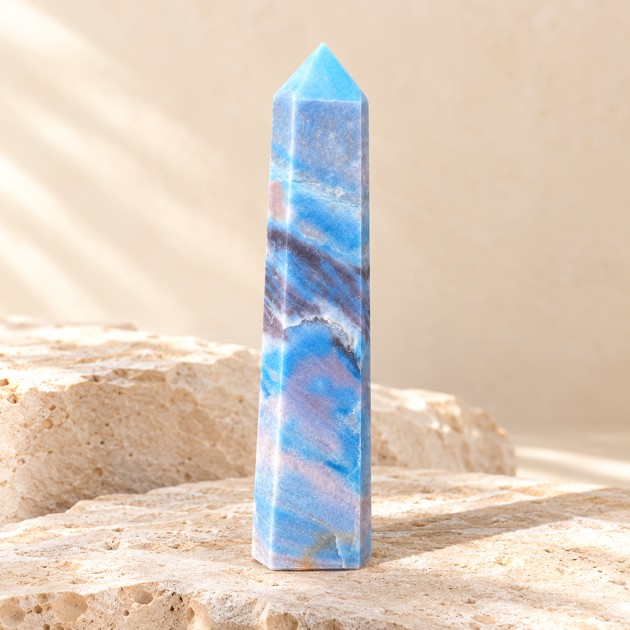 Natural blue trolleite crystal tower on warm ivory limestone