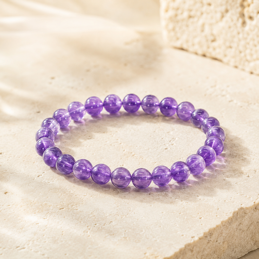 Natural amethyst bead bracelet on warm ivory limestone