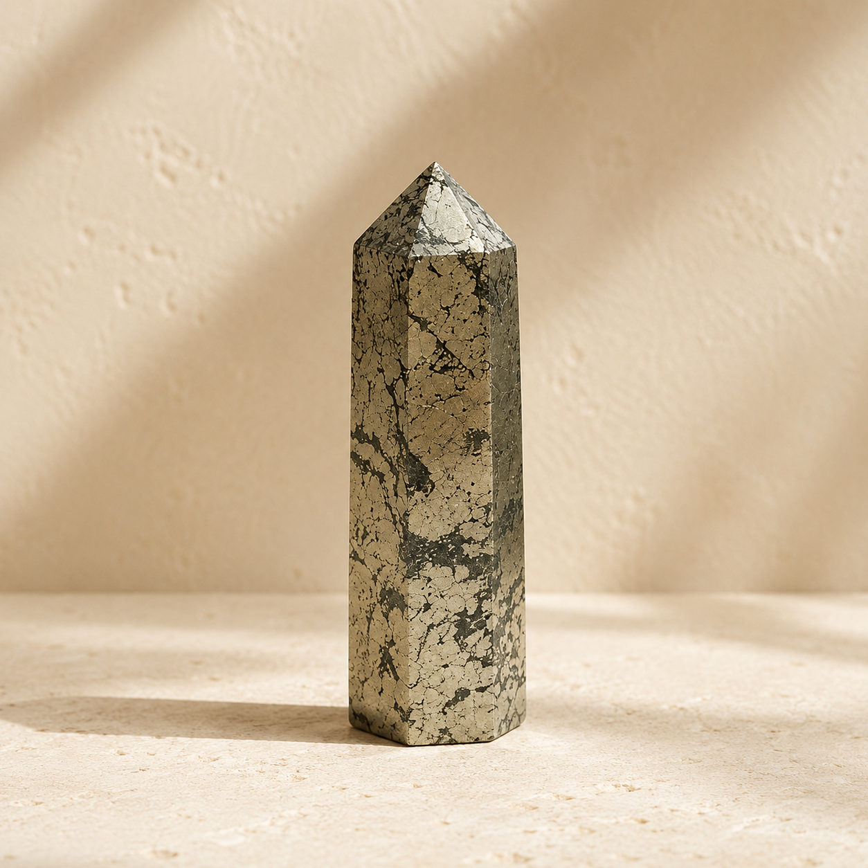 Natural pyrite crystal tower on warm ivory limestone