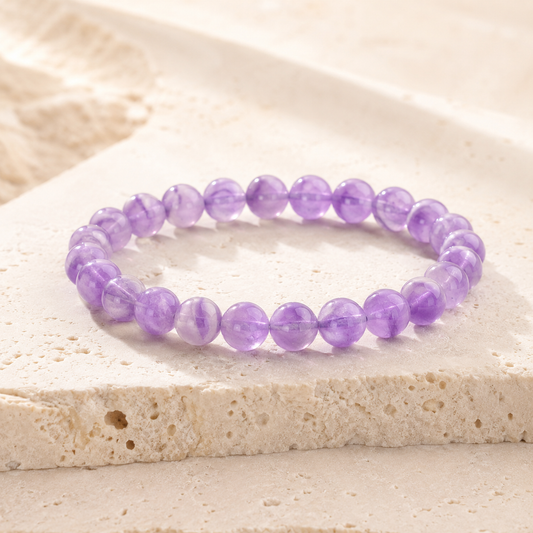 Natural amethyst round bead bracelet on warm ivory limestone